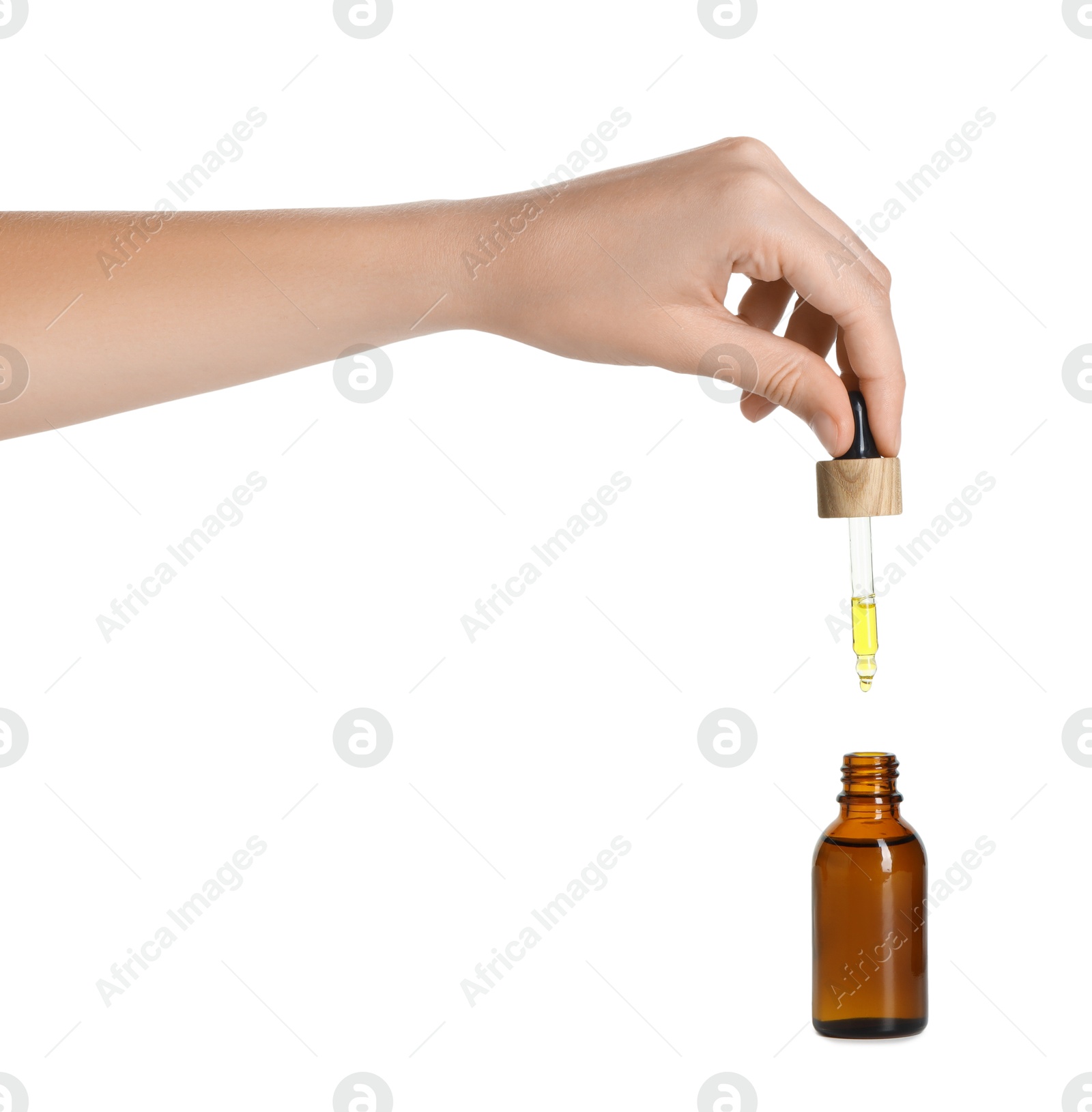 Photo of Woman dripping tincture from pipette into bottle on white background, closeup