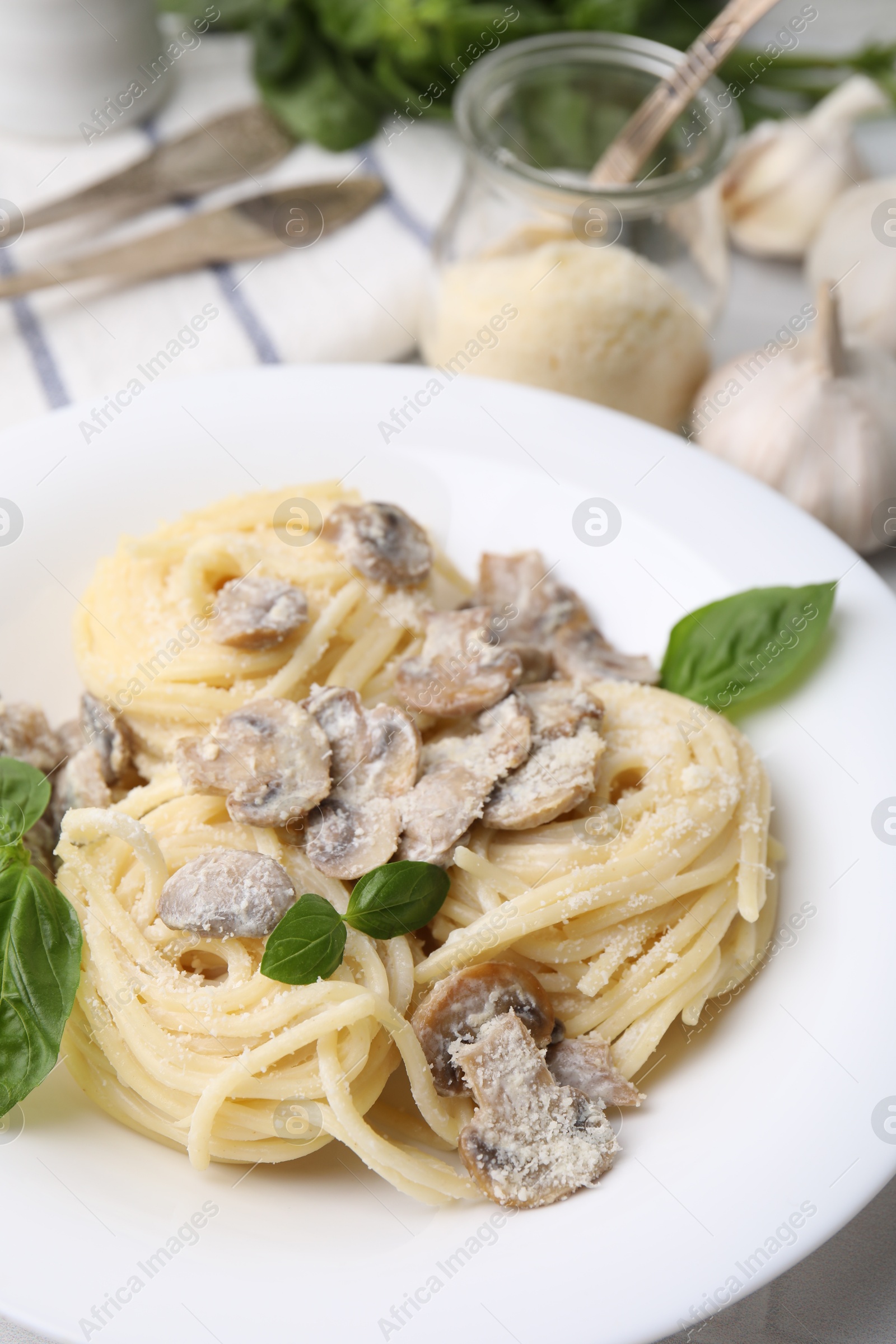 Photo of Delicious pasta with mushrooms and basil on table, closeup