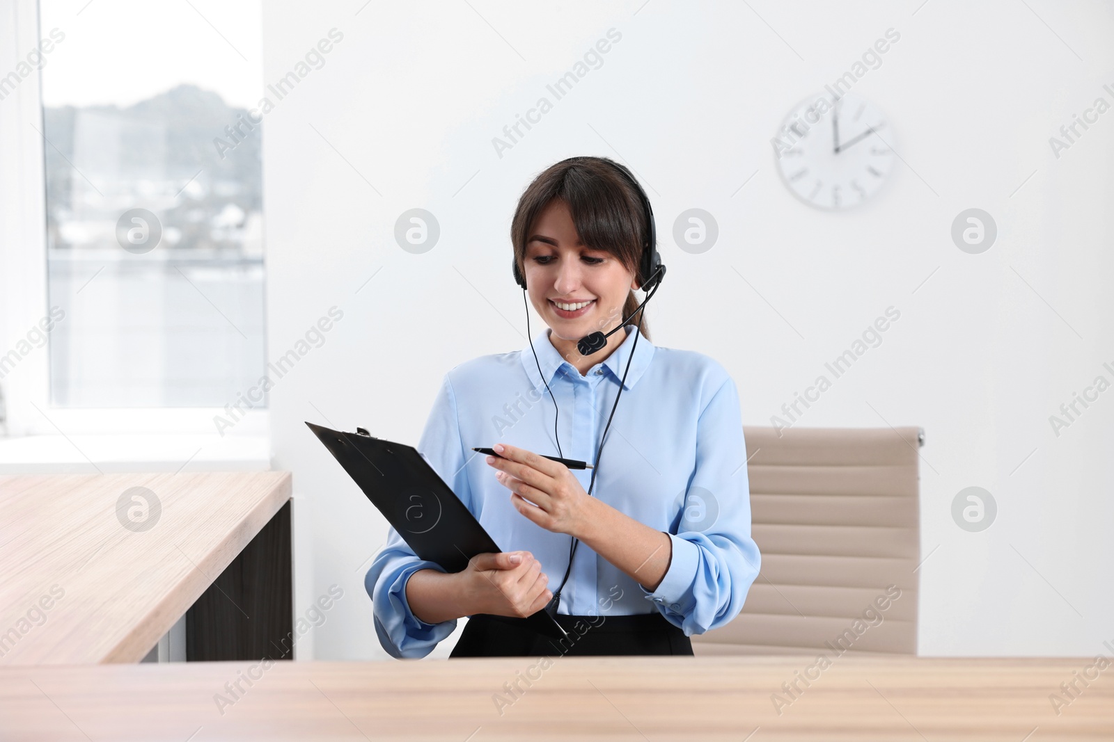 Photo of Professional receptionist working at wooden desk in office