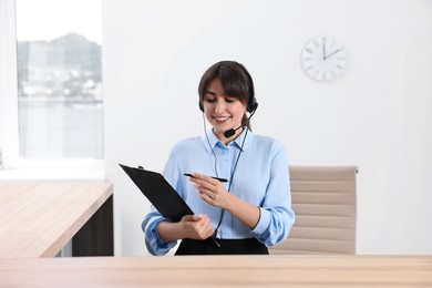 Photo of Professional receptionist working at wooden desk in office