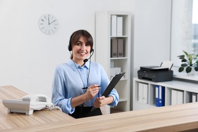 Photo of Professional receptionist working at wooden desk in office