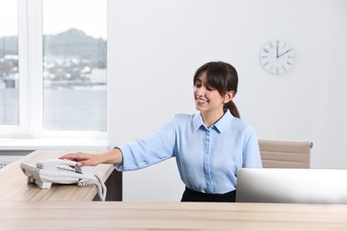 Photo of Professional receptionist working at wooden desk in office