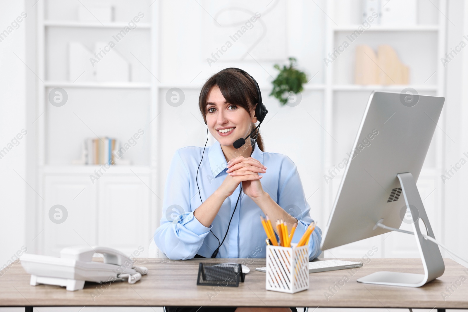 Photo of Portrait of receptionist at wooden desk in office