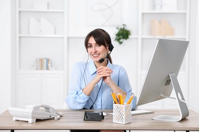 Portrait of receptionist at wooden desk in office