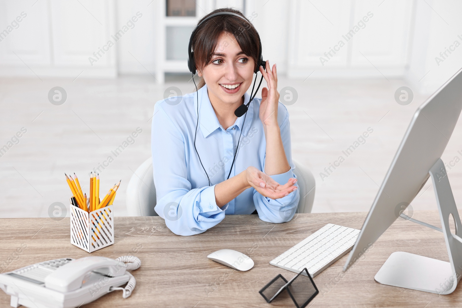 Photo of Professional receptionist working at wooden desk in office