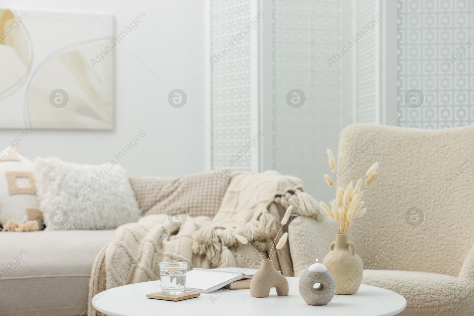 Photo of Coffee table with books and decor near sofa in living room, selective focus