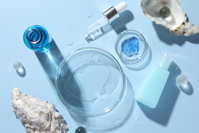 Petri dishes with cosmetic product, pipette and seashells on light blue background, flat lay