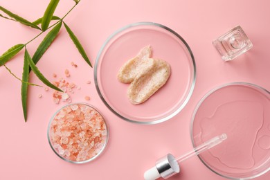 Photo of Petri dishes with cosmetic products, sea salt and leaves on pink background, flat lay