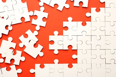 White puzzle pieces on red background, top view