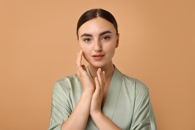 Beautiful young woman with healthy skin on beige background