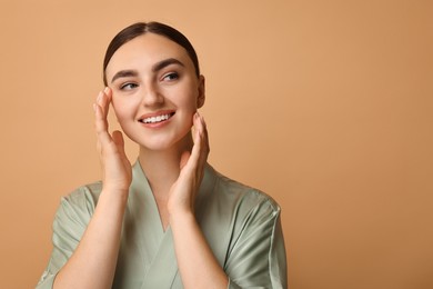 Beautiful young woman with healthy skin on beige background, space for text