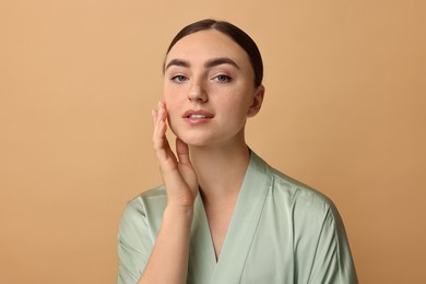 Beautiful young woman with healthy skin on beige background