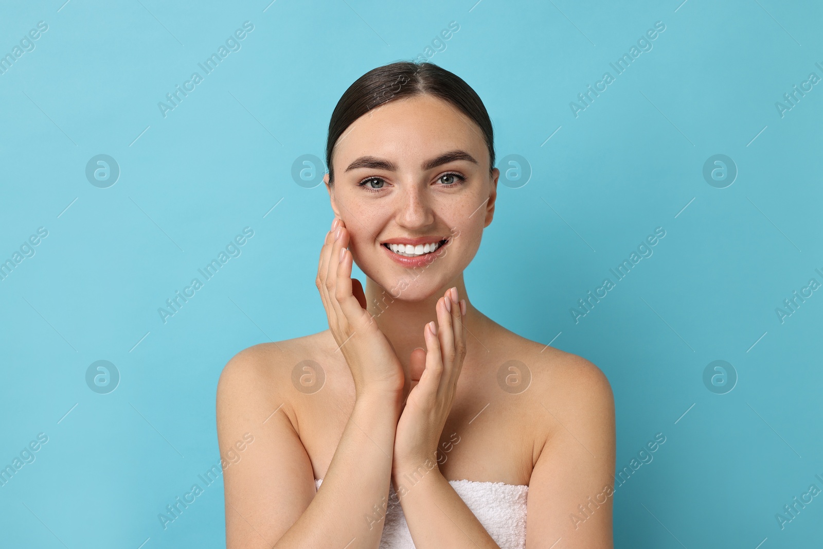 Photo of Beautiful young woman with healthy skin on light blue background