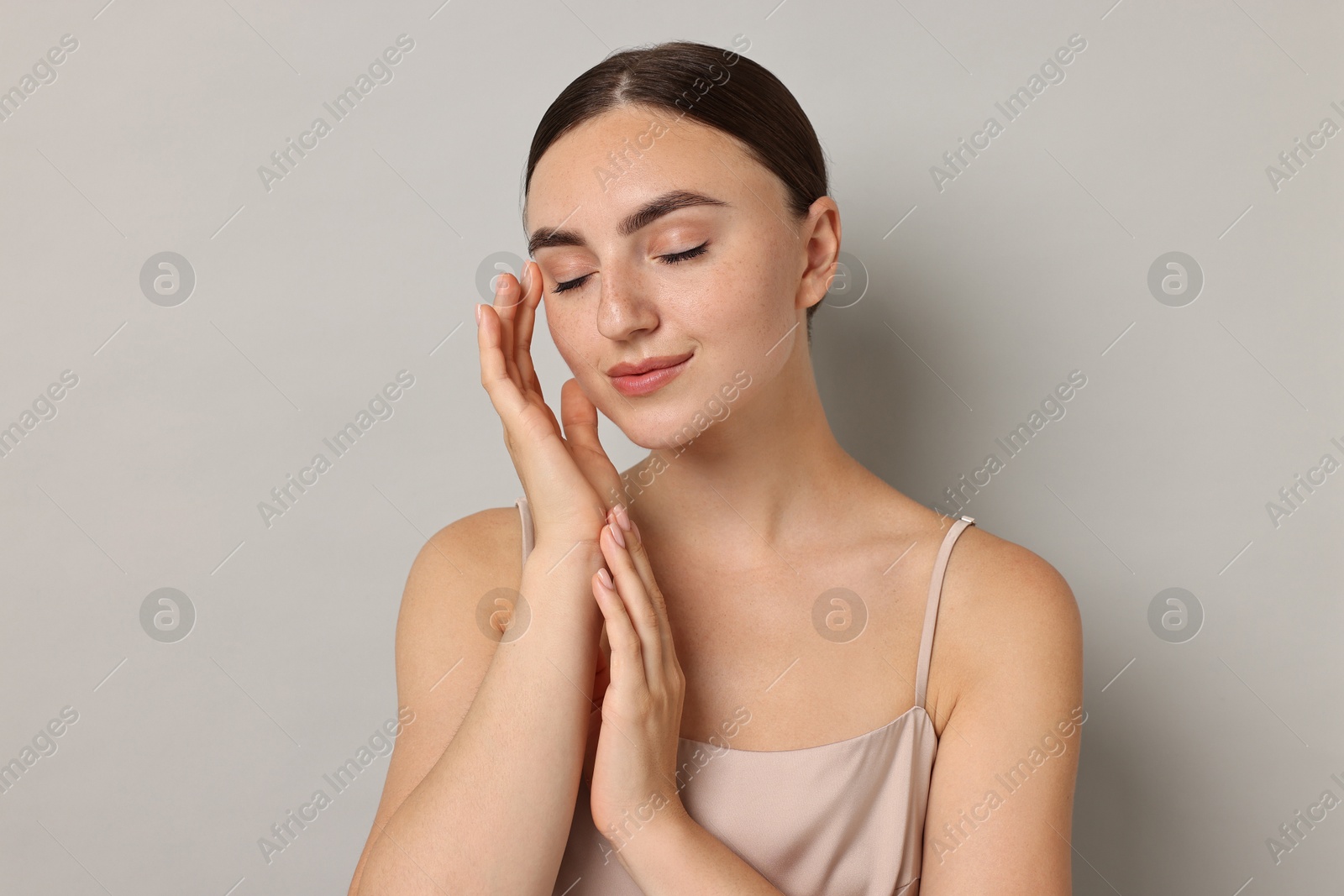 Photo of Beautiful young woman with healthy skin on grey background