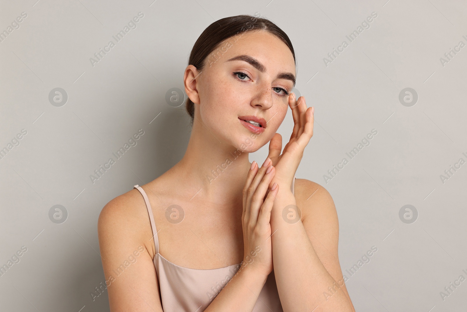 Photo of Beautiful young woman with healthy skin on grey background