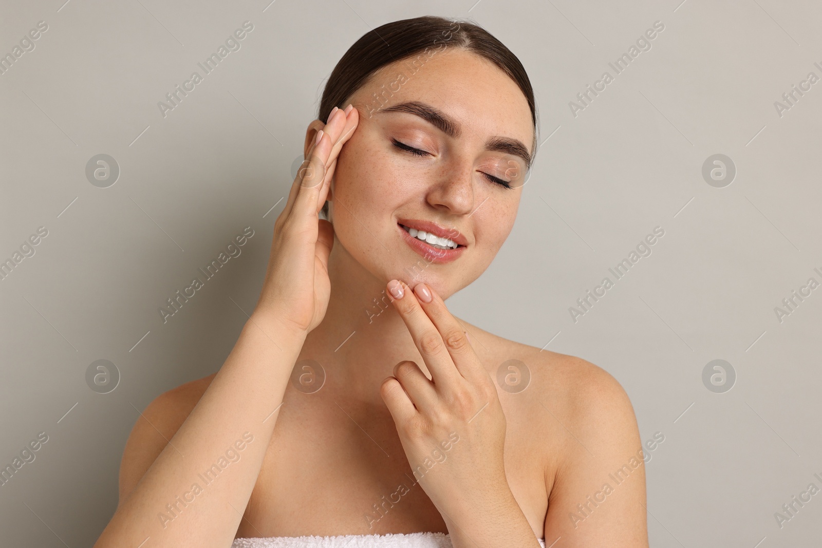 Photo of Beautiful young woman with healthy skin on grey background