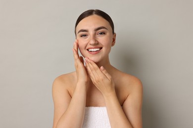 Photo of Beautiful young woman with healthy skin on grey background