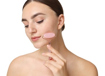 Beautiful young woman doing facial massage with roller on white background