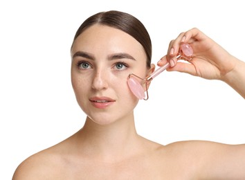 Beautiful young woman doing facial massage with roller on white background