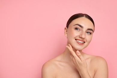 Photo of Face massage. Beautiful young woman with healthy skin on pink background, space for text