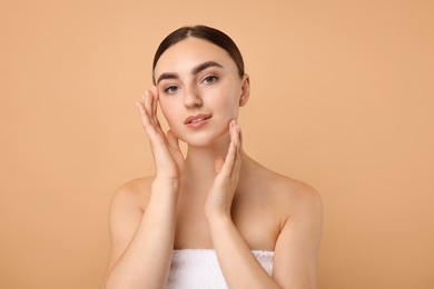 Beautiful young woman with healthy skin on beige background