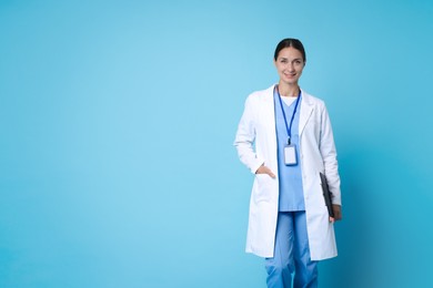 Photo of Nurse in medical uniform with clipboard on light blue background, space for text