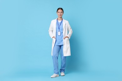 Nurse in medical uniform with badge on light blue background