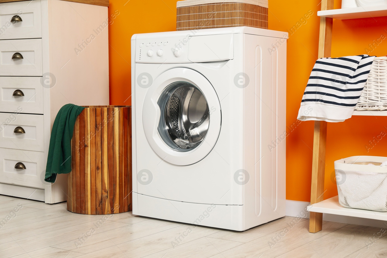 Photo of Washing machine and basket in laundry room