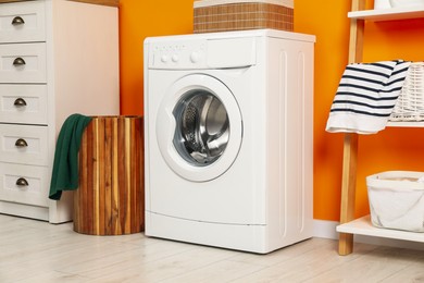 Photo of Washing machine and basket in laundry room