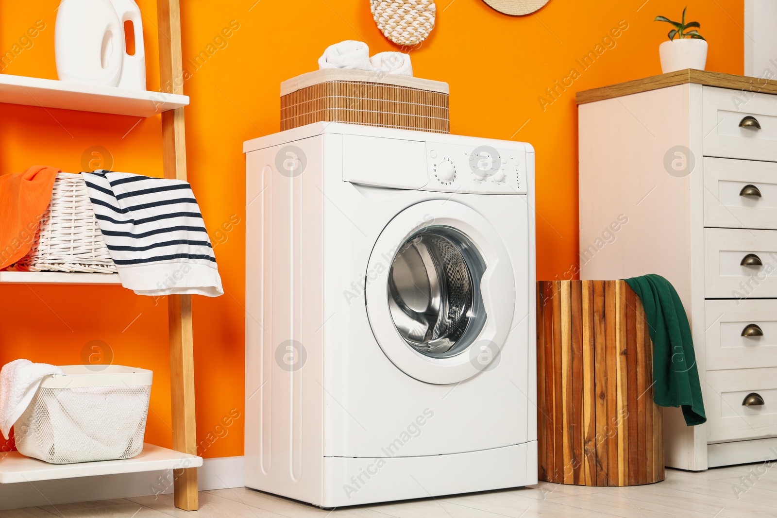 Photo of Washing machine and basket in laundry room