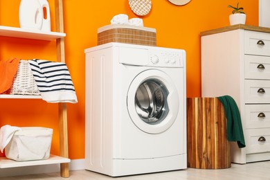 Photo of Washing machine and basket in laundry room