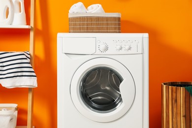 Photo of Washing machine and basket in laundry room