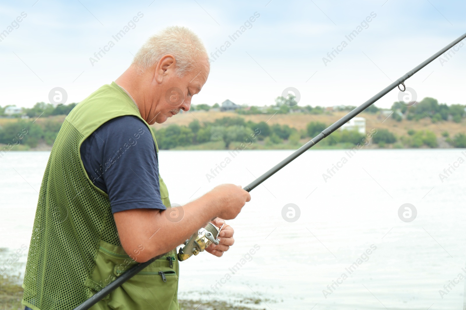 Photo of Fisherman with rod fishing near lake at summer