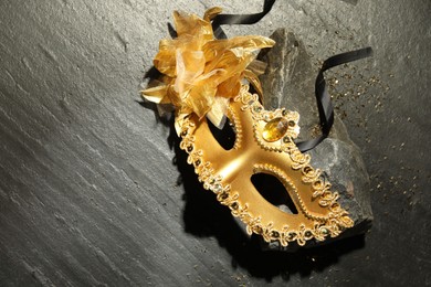 Photo of Beautiful golden carnival mask on grey textured table, top view