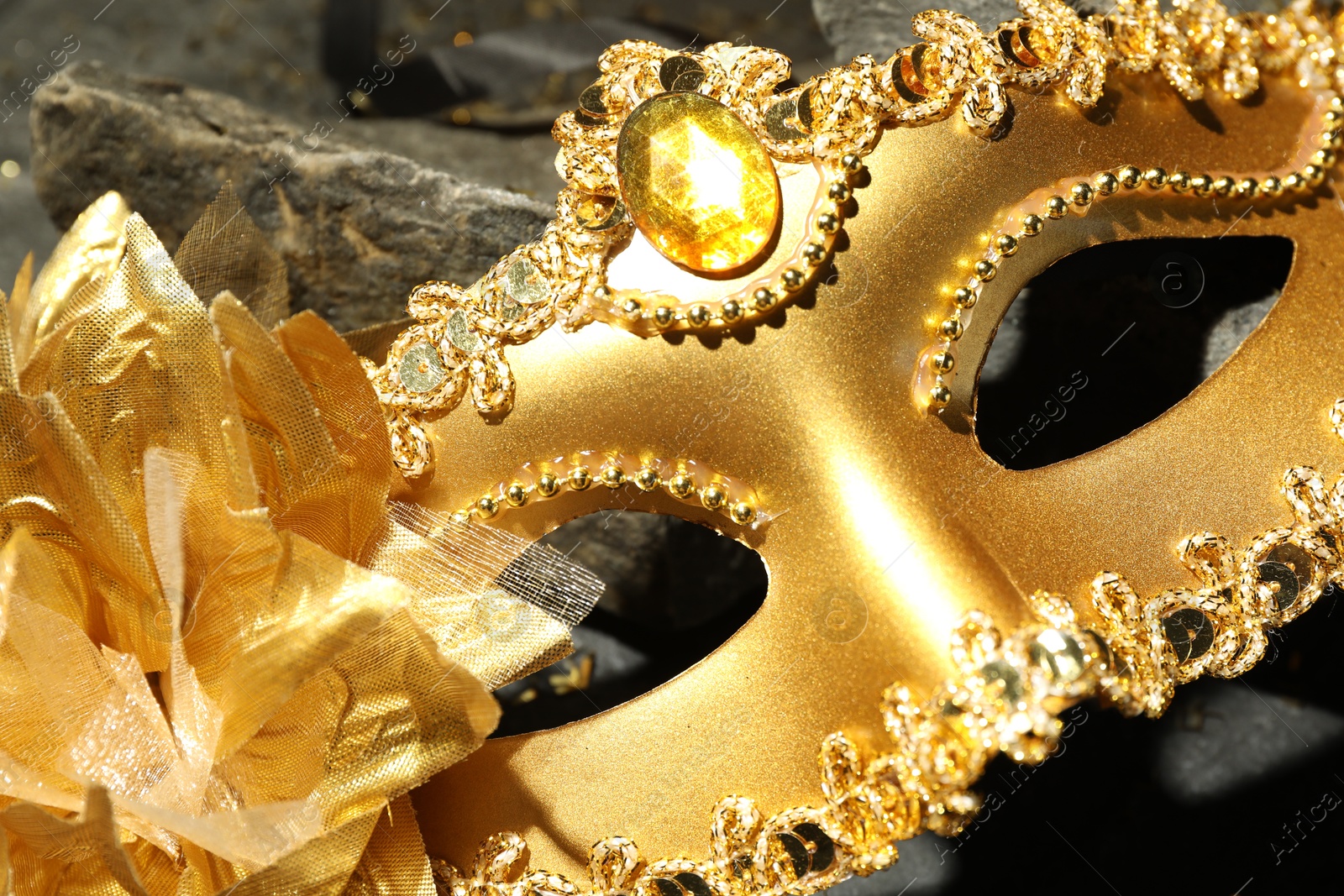 Photo of Beautiful golden carnival mask on table, closeup