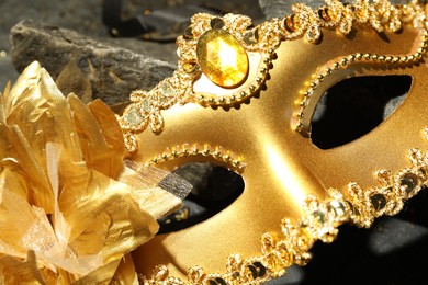 Beautiful golden carnival mask on table, closeup