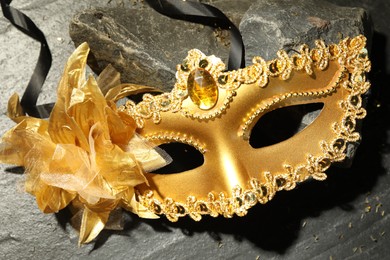 Beautiful golden carnival mask on grey textured table, top view