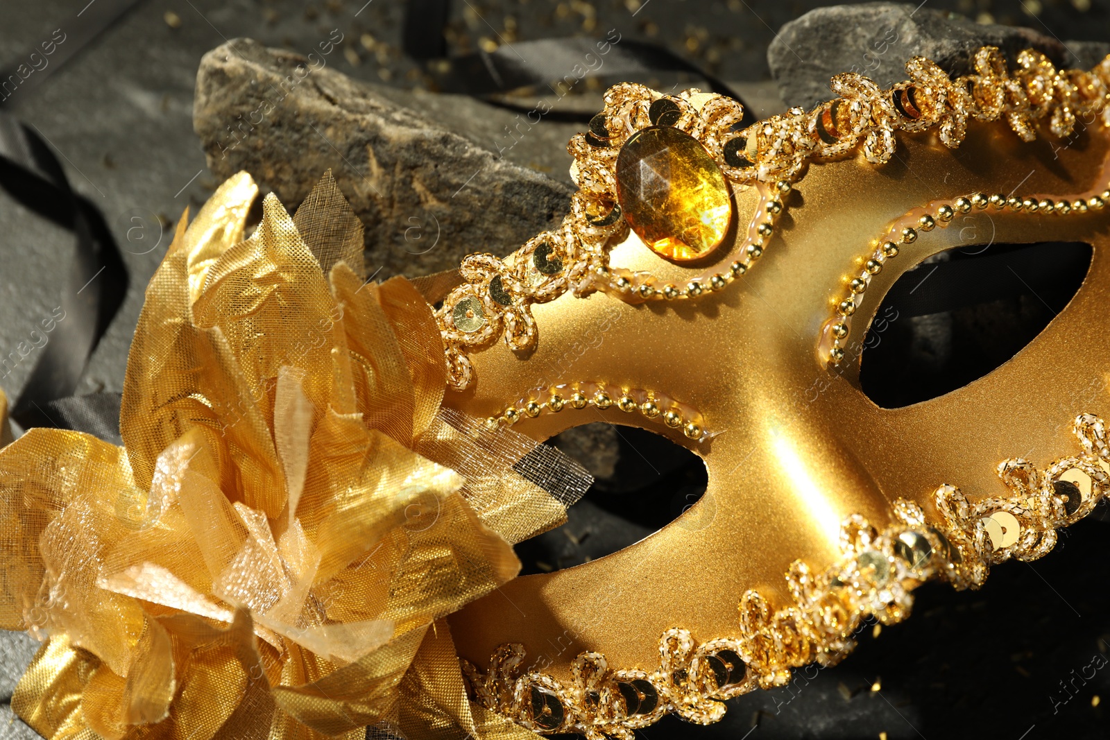 Photo of Beautiful golden carnival mask on table, closeup