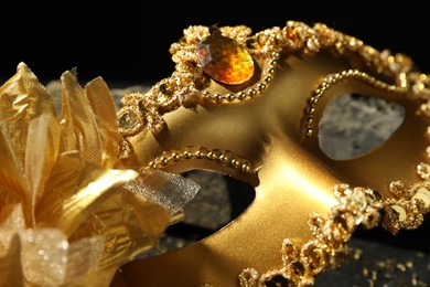 Photo of Beautiful golden carnival mask on table, closeup