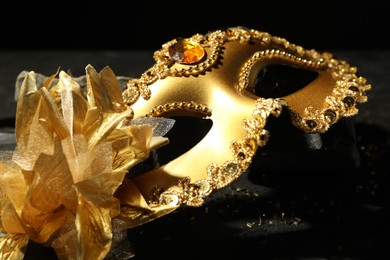 Photo of Beautiful golden carnival mask on table, closeup