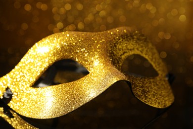 Beautiful golden carnival mask on mirror surface, closeup