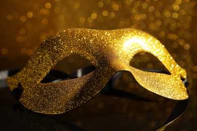 Beautiful golden carnival mask on mirror surface, closeup