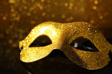 Beautiful golden carnival mask on mirror surface, closeup