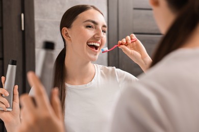 Beautiful woman brushing her teeth in bathroom