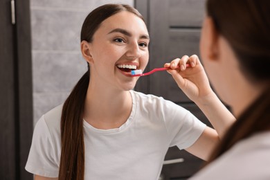 Beautiful woman brushing her teeth in bathroom