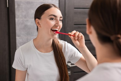 Beautiful woman brushing her teeth in bathroom