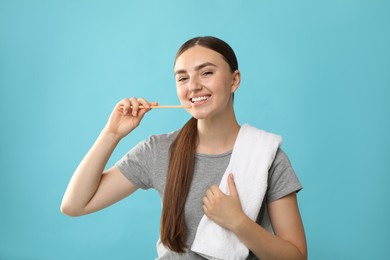 Photo of Beautiful woman brushing her teeth on light blue background