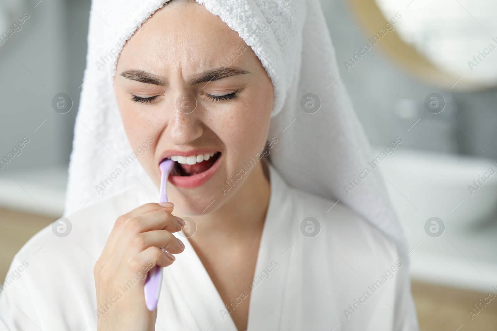 Photo of Young woman with toothbrush suffering from toothache in bathroom