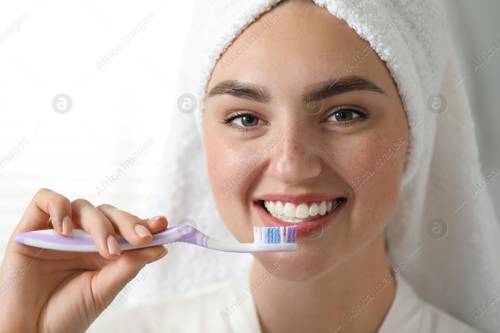 Photo of Beautiful woman brushing her teeth in bathroom