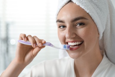 Beautiful woman brushing her teeth in bathroom